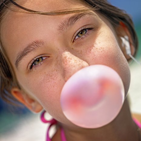 Teenager girl makes chewing gum's bubble